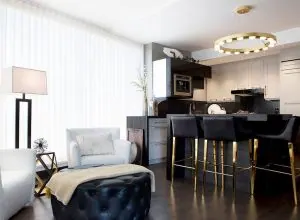 Long white drapes in an open living area with a kitchen island and stools