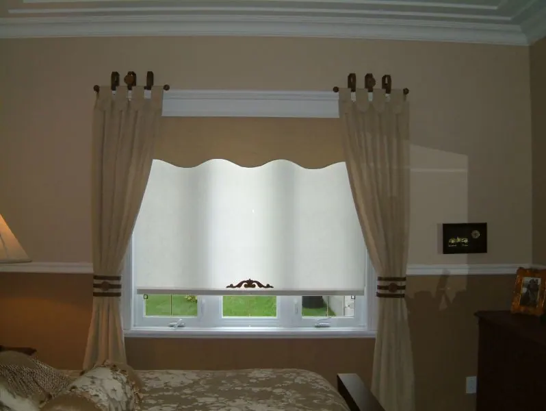 Cantonnière ondulée et rideaux beiges à œillets autour d'une fenêtre de chambre