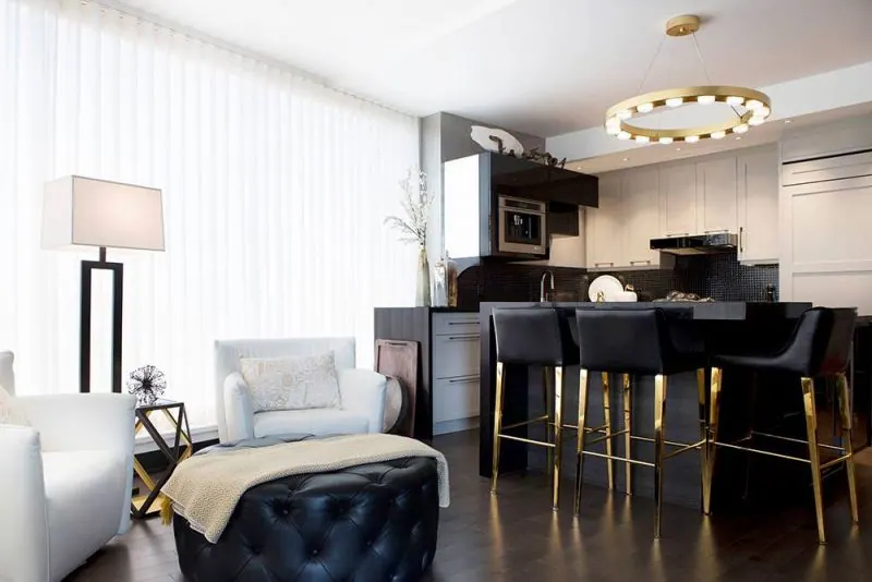 Rideaux blancs légers dans un salon ouvert sur une cuisine sombre