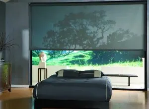Grande toile solaire ouverte sur un paysage, chambre au lit bleu-gris