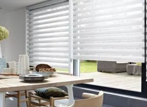 Stores zébrés blancs sur porte vitrée, table à manger sur terrasse