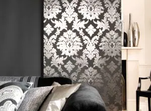 Panneau coulissant damassé argent sur noir, coussins sur un canapé sombre